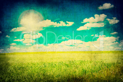 grunge image of green field and blue sky