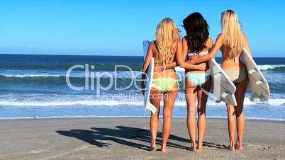 Drei Mädchen mit Surfbrettern