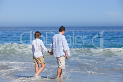 Couple walking on the beach under the sun