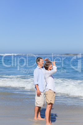 Couple walking on the beach under the sun