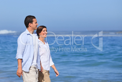 Couple walking on the beach under the sun