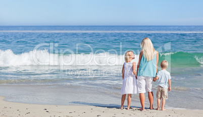 Joyful family walking on the beach