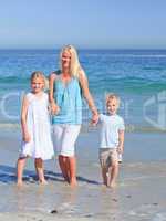 Joyful family walking on the beach