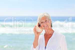 Mature woman listening to her shell