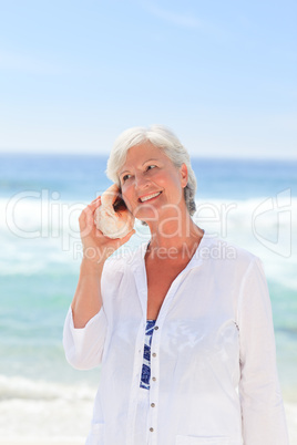 Mature woman listening to her shell
