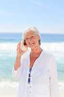 Mature woman listening to her shell