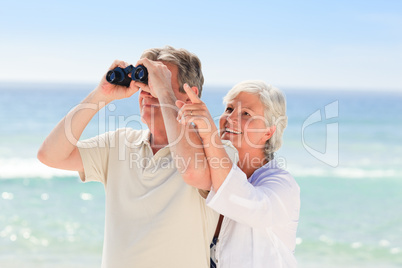 Senior couple bird watching at the beach