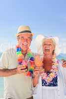 Elderly couple drinking a cocktail on the beach