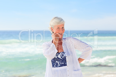 Happy retired woman on the beach