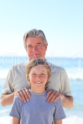 Grandfather with his grandson on the beach