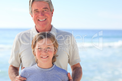 Grandfather with his grandson on the beach