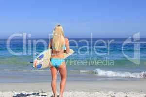Beautiful blonde woman with her surfboard