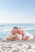 Mature couple lying down on the beach