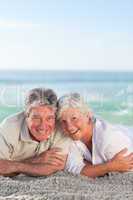 Mature couple lying down on the beach