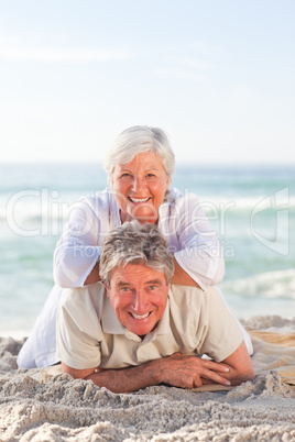 Elderly couple lying down on the beach