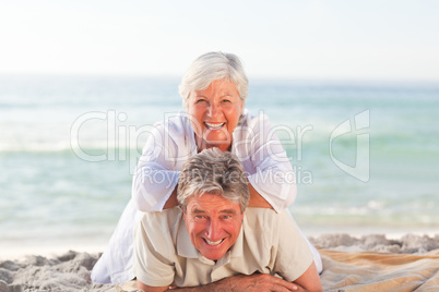 Senior couple lying down on the beach