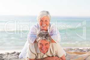 Senior couple lying down on the beach