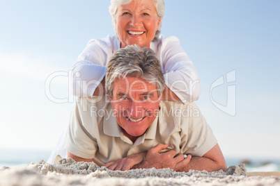 Senior couple lying down on the beach