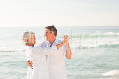 Elderly couple dancing on the beach