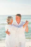 Elderly couple dancing on the beach