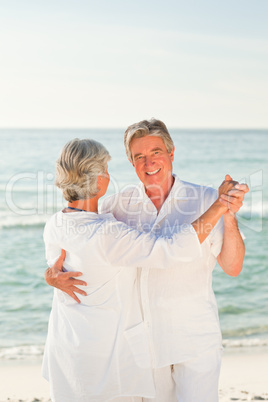 Mature couple dancing on the beach