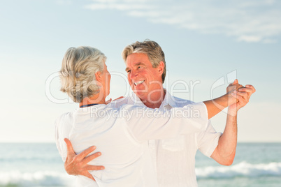 Mature couple dancing on the beach