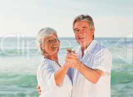 Mature couple dancing on the beach