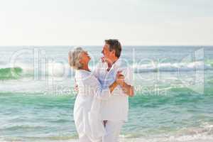 Retired couple dancing on the beach