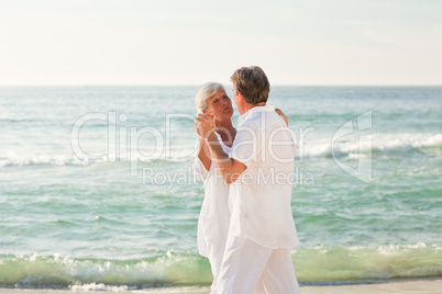 Retired couple dancing on the beach