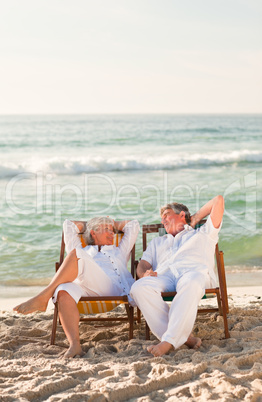 Elderly couple relaxing in their deck chairs