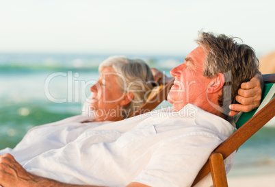 Elderly couple relaxing in their deck chairs