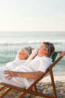 Elderly couple relaxing in their deck chairs