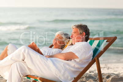 Man reading a book while his wife is sleeping