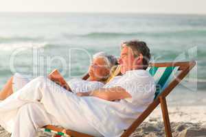 Man reading a book while his wife is sleeping