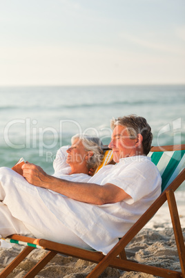 Man reading a book while his wife is sleeping