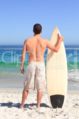 Man wirth his surfboard on the beach