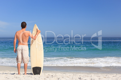 Man wirth his surfboard on the beach