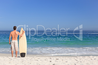 Man wirth his surfboard on the beach