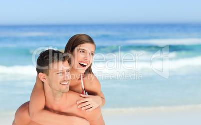 Man having wife a piggyback on the beach