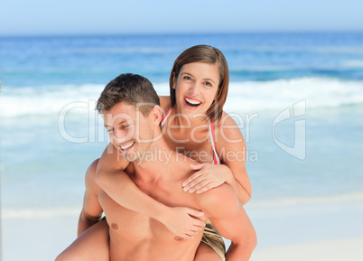 Man having wife a piggyback on the beach