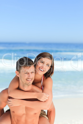 Man having wife a piggyback on the beach