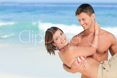 Man carrying his wife at the beach