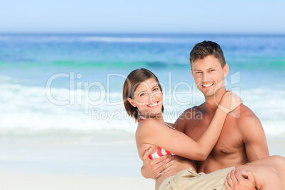 Man carrying his wife at the beach