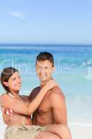 Man carrying his wife at the beach