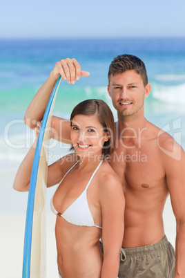 Lovers with their surfboard