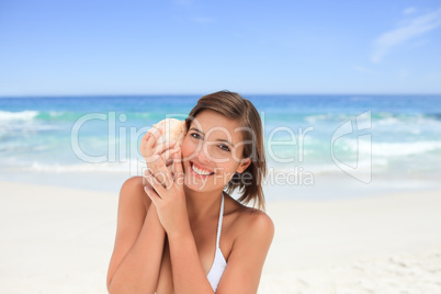 Beautiful woman listening to her shell