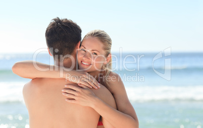 Woman hugging her boyfriend at the beach