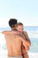 Woman hugging her boyfriend at the beach