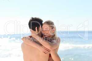 Woman hugging her boyfriend at the beach