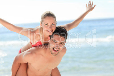 Beautiful man having girlfriend a piggyback